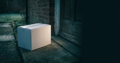 A plain, unbranded delivery box left on a front doorstep.